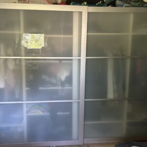 Das ist der klassische IKEA PAX Kleiderschrank mit Schiebetüren aus Milchglas (satiniertem Glas) und einem Aluminiumrahmen.